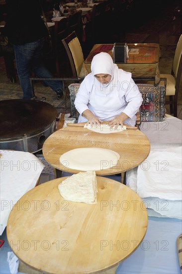 Turkey, Istanbul, Sultanahmet woman rolling out bread dough in restaurant. 
Photo : Stephen Rafferty