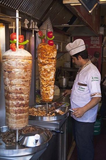 Turkey, Istanbul, Sultanahmet man in kebab restaurant carving shawarma from skewered meats. 
Photo : Stephen Rafferty