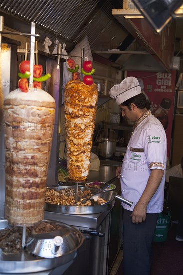 Turkey, Istanbul, Sultanahmet man in kebab restaurant carving shawarma from skewered meats. 
Photo : Stephen Rafferty