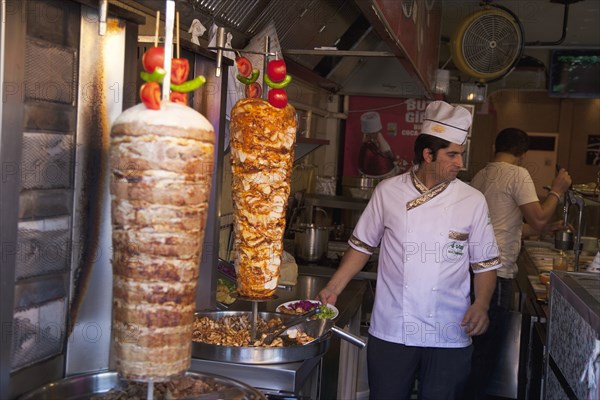 Turkey, Istanbul, Sultanahmet man in kebab restaurant carving shawarma from skewered meats. 
Photo : Stephen Rafferty