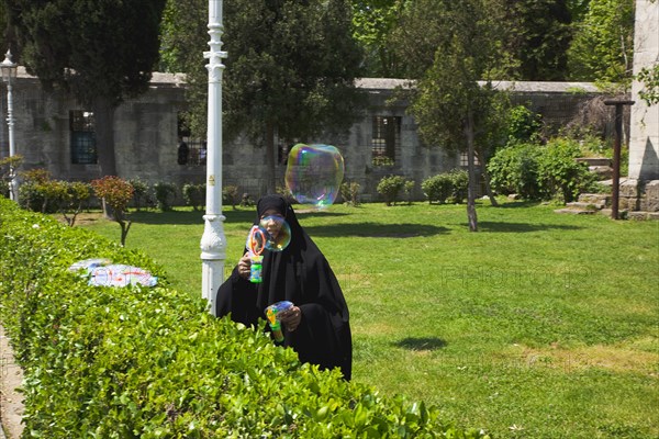 Turkey, Istanbul, Sultanahmet woman selling bubvble gun machine in park outside the Blue Mosque. 
Photo : Stephen Rafferty