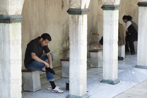 Turkey, Istanbul, Sultanahmet Camii Blue Mosque man preparing to wash feet before worship. 
Photo : Stephen Rafferty
