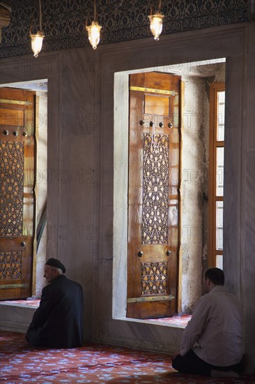 Turkey, Istanbul, Sultanahmet Camii Blue Mosque interior with men at worship. 
Photo : Stephen Rafferty