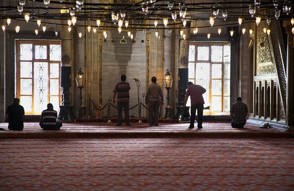 Turkey, Istanbul, Sultanahmet Camii Blue Mosque interior with men at worship. 
Photo : Stephen Rafferty