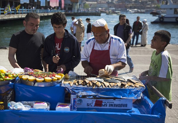 Turkey, Istanbul, Karakoy Galata fish market man selling freshly grilled fish served in bread roll. 
Photo : Stephen Rafferty