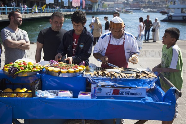 Turkey, Istanbul, Karakoy Galata fish market man selling freshly grilled fish served in bread roll. 
Photo : Stephen Rafferty