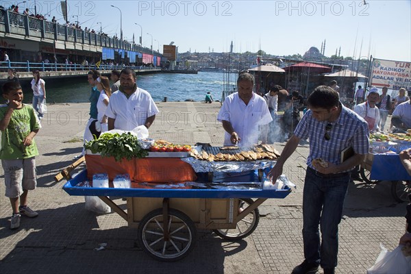 Turkey, Istanbul, Karakoy Galata fish market man selling freshly grilled fish served in a bread roll. 
Photo : Stephen Rafferty