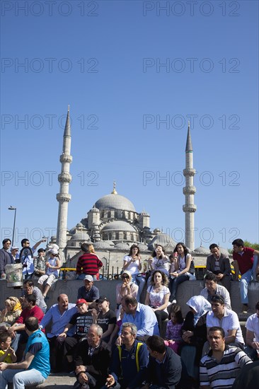 Turkey, Istanbul, Eminonu Yeni Camii New Mosque people on sat on steps next to the subway. 
Photo : Stephen Rafferty