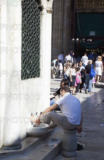 Turkey, Istanbul, Eminonu Yeni Camii New Mosque worshippers washing feet in courtyard. 
Photo : Stephen Rafferty