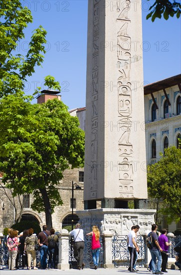 Turkey, Istanbul, Sultanahmet Tourists in the Roman Hippodrome in At Meydani beside Egyptian Obelisk with Hieroglyphics from Luxor and relief at base showing Theodosius I and courtiers. 
Photo : Paul Seheult