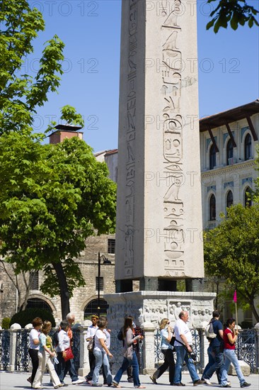 Turkey, Istanbul, Sultanahmet Tourists in the Roman Hippodrome in At Meydani beside Egyptian Obelisk with Hieroglyphics from Luxor and relief at base showing Theodosius I and courtiers. 
Photo : Paul Seheult