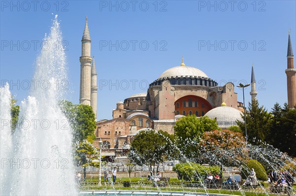 Turkey, Istanbul, Sultanahmet Haghia Sophia with dome and minarets beyond the water fountain in the gardens with sightseeing tourists. 
Photo : Paul Seheult