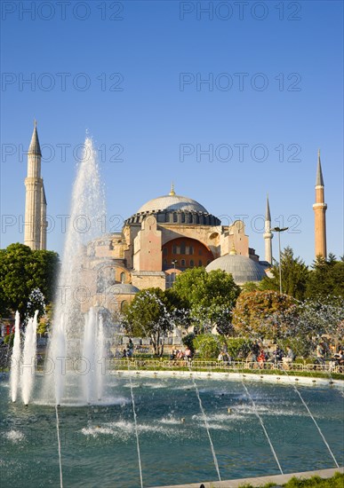 Turkey, Istanbul, Sultanahmet Haghia Sophia with dome and minarets beyond the water fountain in the gardens with sightseeing tourists. 
Photo : Paul Seheult