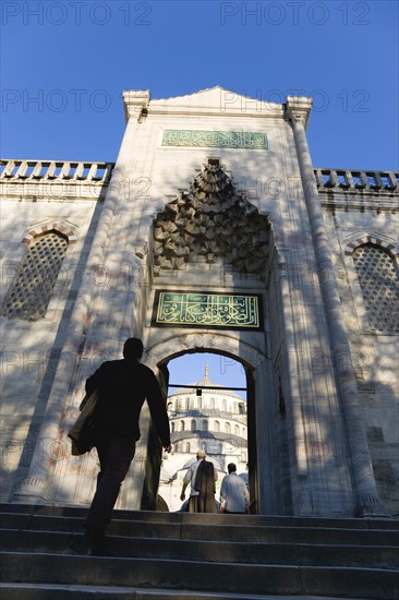 Turkey, Istanbul, Sultanahmet Camii The Blue Mosque Courtyard and dome seen through the exit to the Hippodrome with people entering through doorway. 
Photo : Paul Seheult