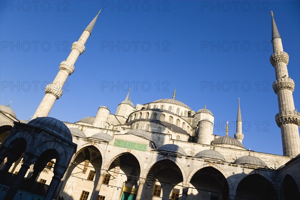 Turkey, Istanbul, Sultanahmet Camii The Blue Mosque domes seen from the Courtyard with Arabic text from the Koran in green and the Absolution Fountain in the foreground. 
Photo : Paul Seheult