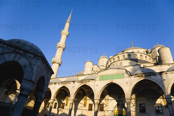 Turkey, Istanbul, Sultanahmet Camii The Blue Mosque domes seen from the Courtyard with Arabic text from the Koran in green and the Absolution Fountain in the foreground. 
Photo : Paul Seheult