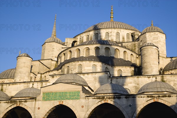 Turkey, Istanbul, Sultanahmet Camii The Blue Mosque domes seen from the Courtyard with Arabic text from the Koran. 
Photo : Paul Seheult