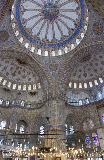 Turkey, Istanbul, Sultanahmet Camii The Blue Mosque interior with decorated painted domes with chandelier below. 
Photo : Paul Seheult