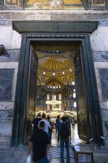 Turkey, Istanbul, Sultanahmet Haghia Sophia People walking through the Imperial Gate with mosaics above and the Nave of the Cathedral beyond. 
Photo : Paul Seheult