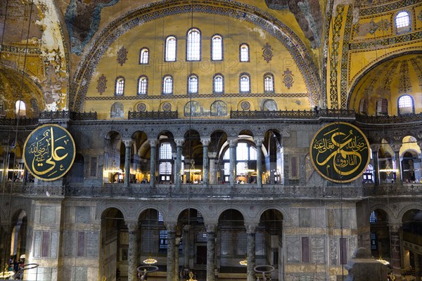 Turkey, Istanbul, Sultanahmet Haghia Sophia Sightseeing tourists in the North Gallery with Koranic Islamic calligraphic roundels of Arab text. 
Photo : Paul Seheult