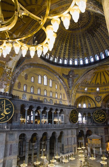 Turkey, Istanbul, Sultanahmet Haghia Sophia Sighseeing tourists beneath the dome with murals and chandeliers in the Nave of the Cathedral. 
Photo : Paul Seheult