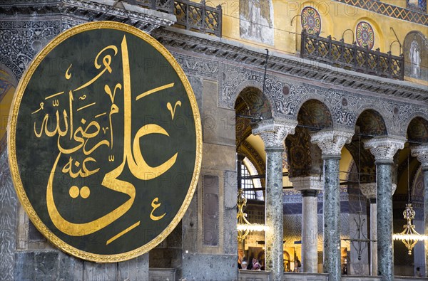 Turkey, Istanbul, Sultanahmet Haghia Sophia Sightseeing tourists in the North Gallery with Koranic Islamic calligraphic roundels of Arab text. 
Photo : Paul Seheult