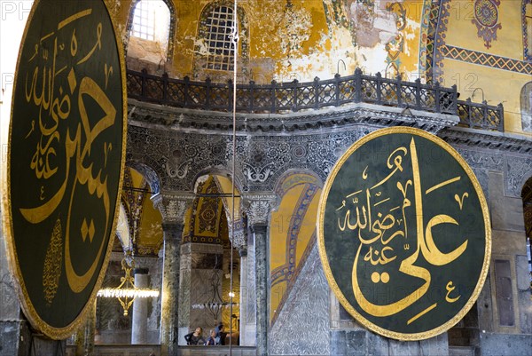 Turkey, Istanbul, Sultanahmet Haghia Sophia Sightseeing tourists in the North Gallery with Koranic Islamic calligraphic roundels of Arab text. 
Photo : Paul Seheult