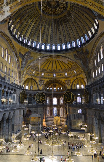 Turkey, Istanbul, Sultanahmet Haghia Sophia Sightseeing tourists beneath the dome with murals and chandeliers in the Nave of the Cathedral. 
Photo : Paul Seheult