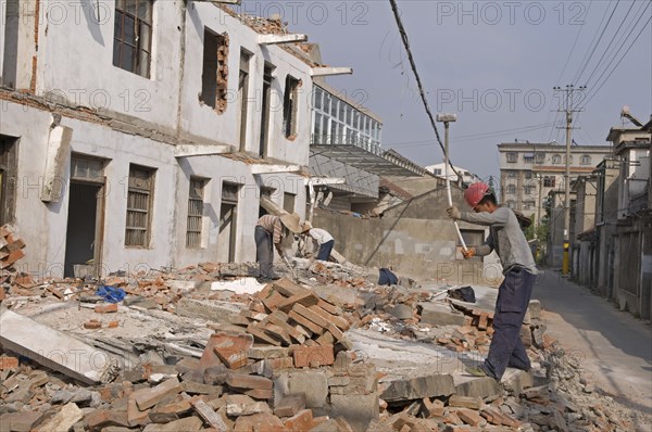 China, Jiangsu, Qidong, Demolition workers using hammers with flexible handles to demolish old residential buildings. 
Photo : Trevor Page