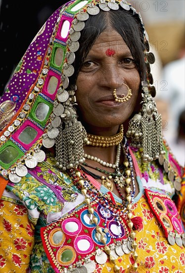 PORTRAIT OF A LAMBANI GYPSY TRIBAL WOMAN WITH TRADITIONAL TRIBAL JEWELRY AND COSTUME, INDIA. (MR)