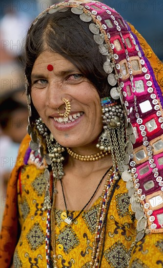 PORTRAIT OF A LAMBANI GYPSY TRIBAL WOMAN WITH TRADITIONAL TRIBAL JEWELRY AND COSTUME, INDIA. (MR)