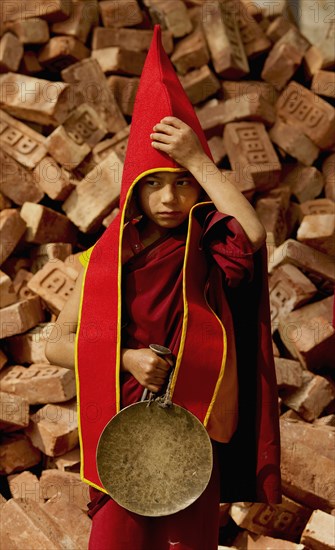 Student Buddhist Lama Monk carrying a gong for the Losar procession, Sikkim, India