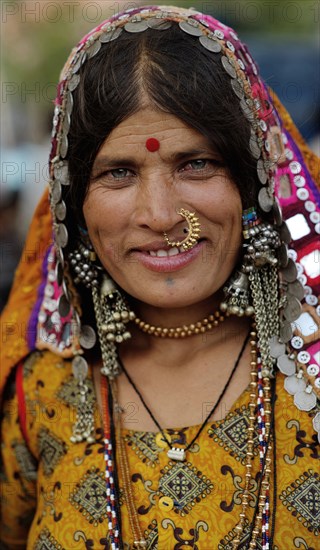 PORTRAIT OF A LAMBANI GYPSY TRIBAL WOMAN WITH TRADITIONAL TRIBAL JEWELRY AND COSTUME, INDIA. (MR)