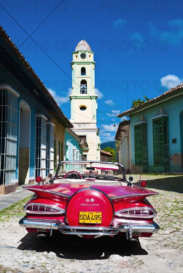 Cuba, Sancti Spiritus, Trinidad, Red 1957 Chevrolet convertible car parked in cobbled street. 
Photo : Richard Rickard