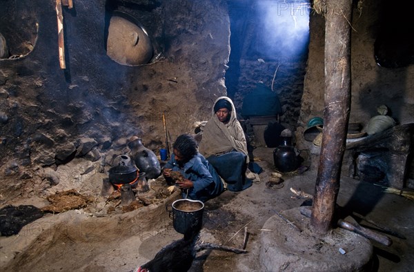 Ethiopia, People, Inside a rural house with women cooking by open fire fueled by animal dung. 
Photo : Adrian Arbib