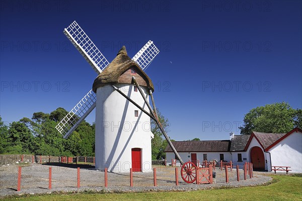Ireland, County Roscommon, Elphin, Windmill. Painted white with red door. Built c.1730 and restored in 1996. Thatched rye rotating roof with four timber sails. 
Photo : Hugh Rooney