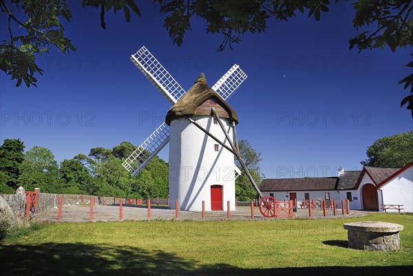 Ireland, County Roscommon, Elphin, Windmill. Painted white with red door. Built c.1730 and restored in 1996. Thatched rye rotating roof with four timber sails. 
Photo : Hugh Rooney