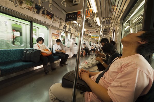 Japan, Honshu, Tokyo, Commuters asleep on train. 
Photo : Jon Burbank