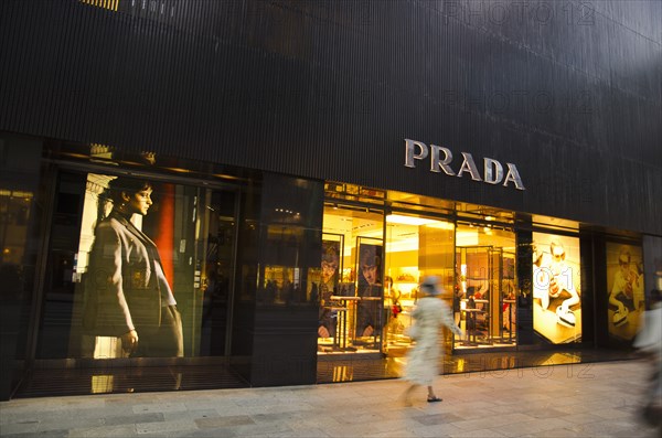 Japan, Honshu, Tokyo, Ginza shopper walking by the Prada store on Chou-dori Avenue. 
Photo : Jon Burbank