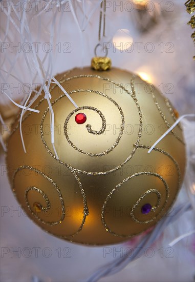 Festivals, Christmas, Decorations gold coloured bauble with white tinsel and fairy lights. 
Photo : Stephen Rafferty