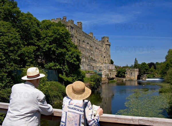 England, Warwickshire, Wawick Castle, Couple looking at castle from bridge over the river Avon. 
Photo : Chris Penn