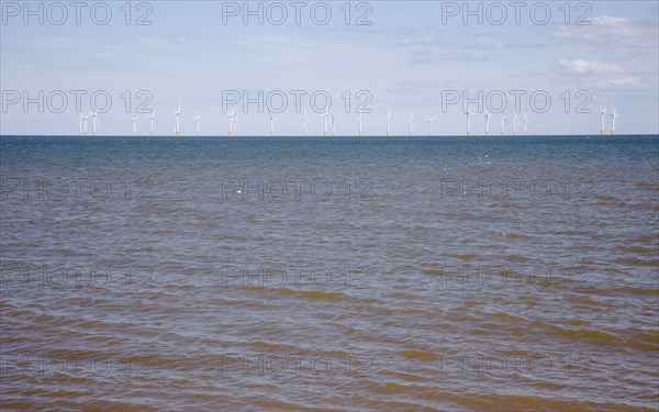 Wind Farm offshore on the horizon showing turbine blades.