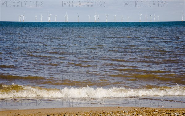 Wind Farm offshore on the horizon showing turbine blades.