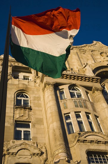 Hungarian Flag flying with Art Nouveau facade behind in central Pest.