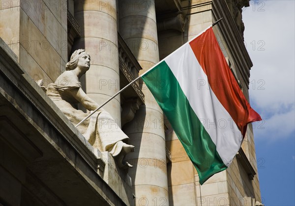 Hungarian Flag flying with Art Nouveau facade behind in central Pest.