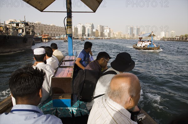 Abra water taxis passing on the Creek with Twin Towers and skyline behind.