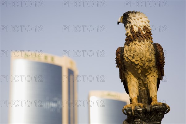 Falcon ststue on the Creek with Twin Towers shopping mall behind.