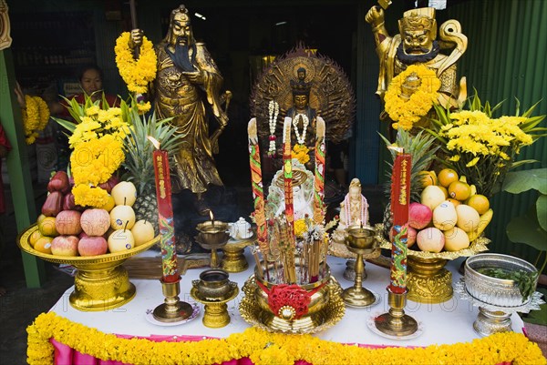 Offerings on table with Guanyin Goddess of Mercy statue in centre celebrating local temple.