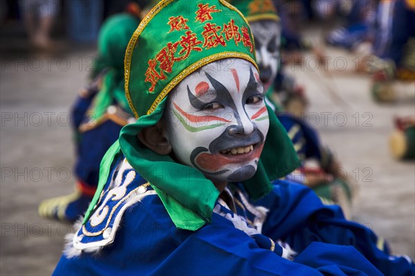 Thai boy in Chinese character costume in dance troupe celebrating local temple.