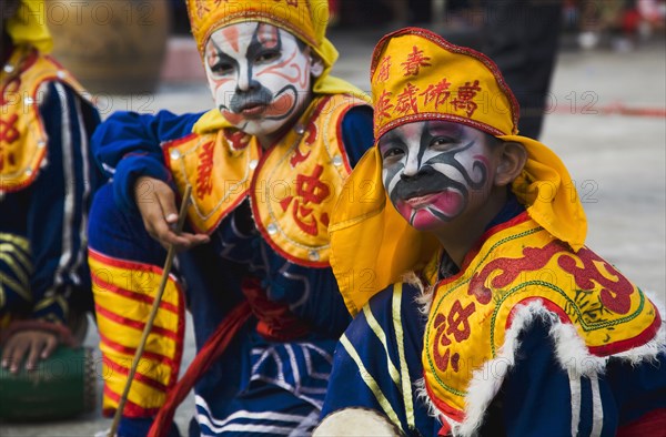 Thai boys in Chinese character costume in dance troupe celebrating local temple.